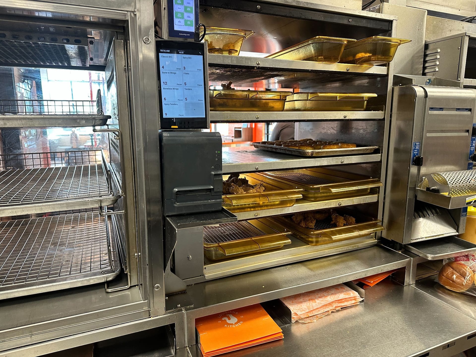 Holding cabinet with a small tablet showing product counts.